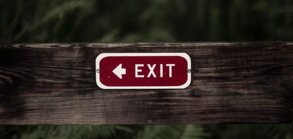 Employee retention rate – red exit sign on a wooden fence