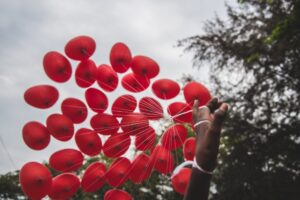 Hand holding red balloons - Birmingham Children's Hospital Charity partnership announcement