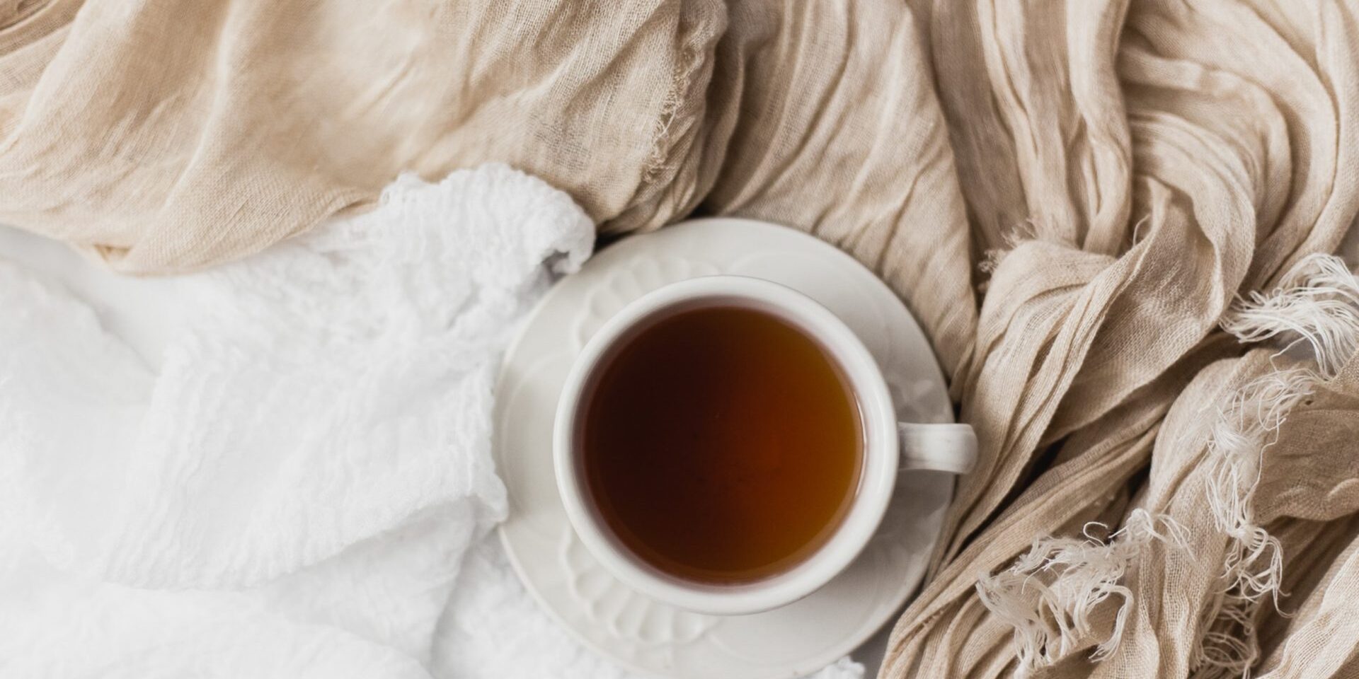A cup of black tea resting on white and cream blankets – our case study for Twinings careers