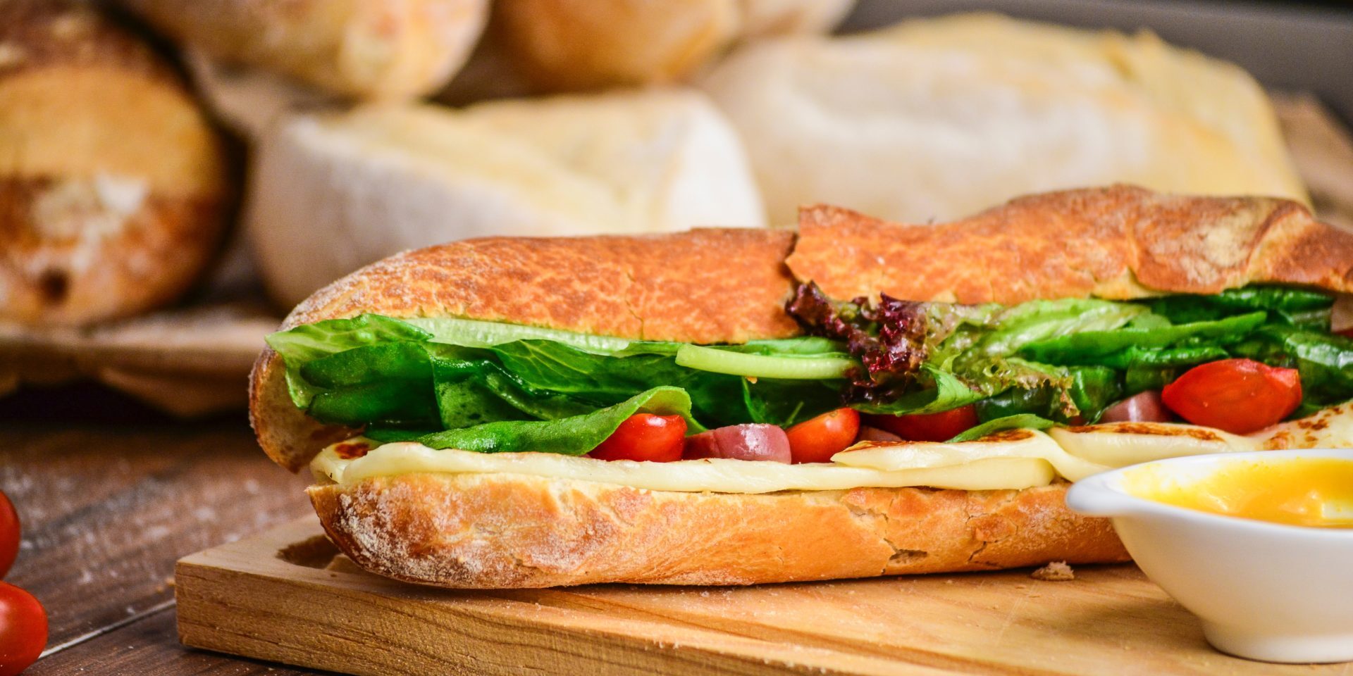 A salad filled baguette on a wooden chopping board – our case study for Adelie Foods careers