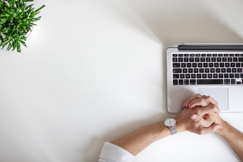 Top five video interview tips: Hands clasped together on top of open laptop